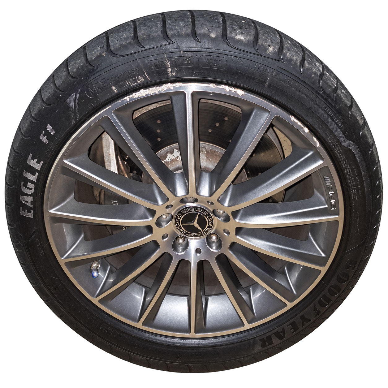 Isolated Mercedes AMG wheel before repair, with curb rash along the upper rim edge